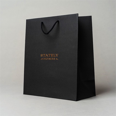 Black paper shopping bag with cord handles and gold detail